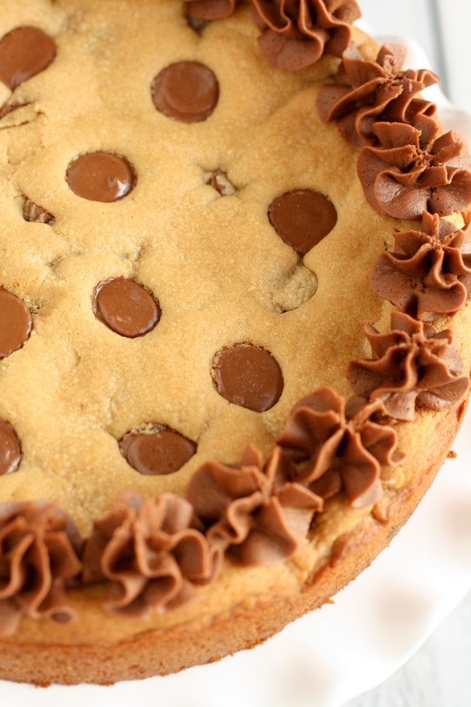 A giant cookie cake topped with chocolate frosting. 