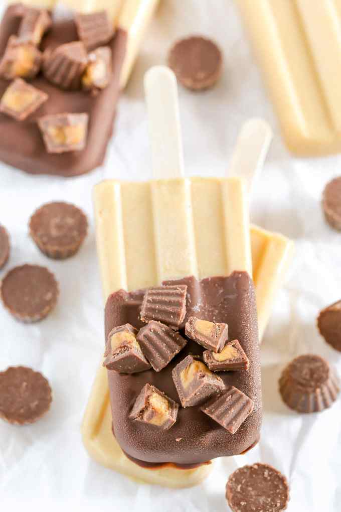 Peanut butter popsicles topped with magic shell and mini peanut butter cups. These Peanut Butter Cup Pudding Pops are a delicious and easy summer treat!