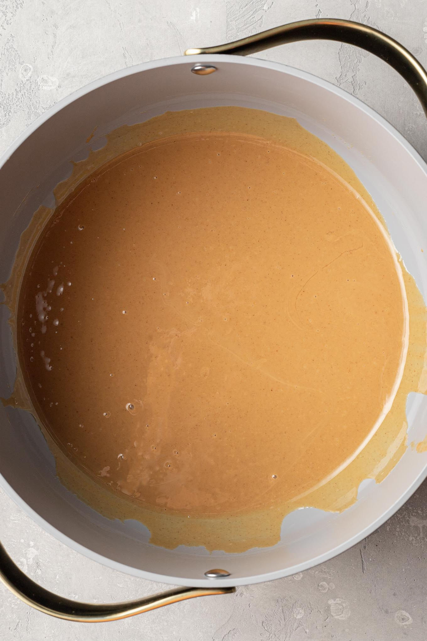 An overhead view of melted butter and peanut butter in a saucepan.