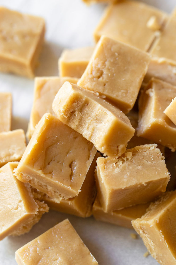 Pieces of Peanut Butter Fudge stacked with the top piece having a bite taken out.