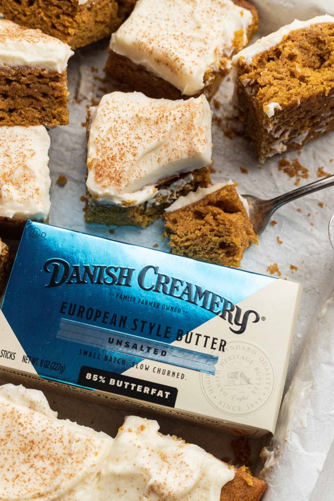 A package of Danish Creamery butter amidst sliced pumpkin bars. 