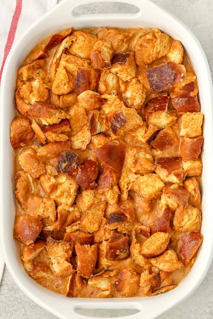 Overhead view of unbaked bread pudding in a white baking dish. 