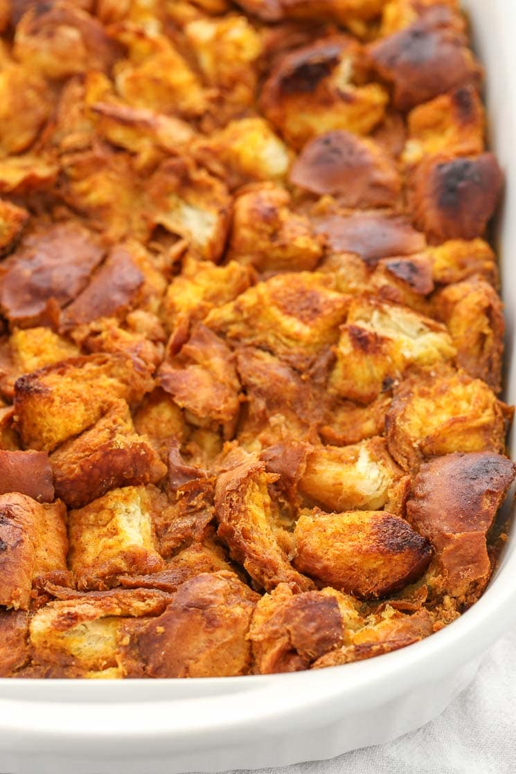 A white baking dish full of pumpkin bread pudding. 