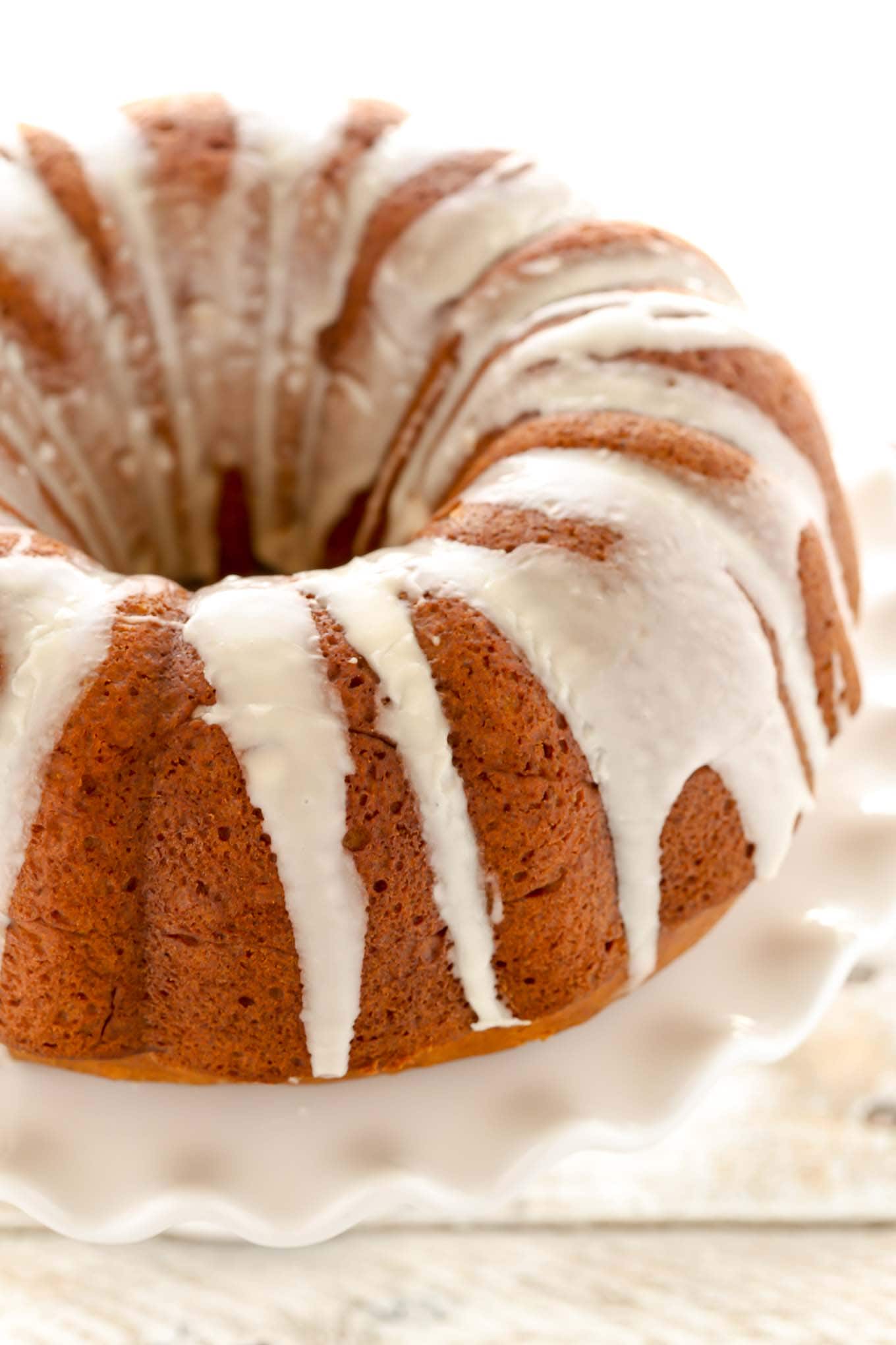 A homemade pumpkin bundt cake filled with cream cheese and topped with vanilla glaze.