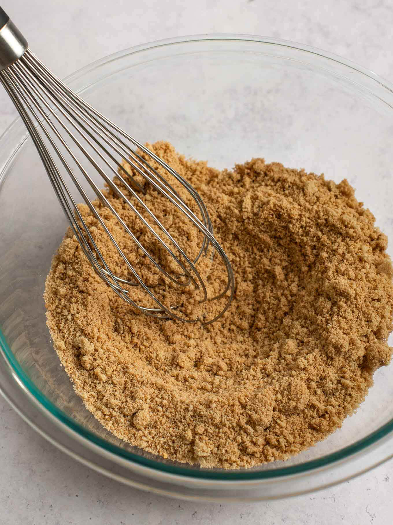 Brown sugar, flour, and spices whisked together in a mixing bowl.