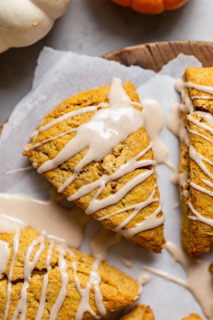 An overhead image of a pumpkin scone topped with maple cinnamon glaze.