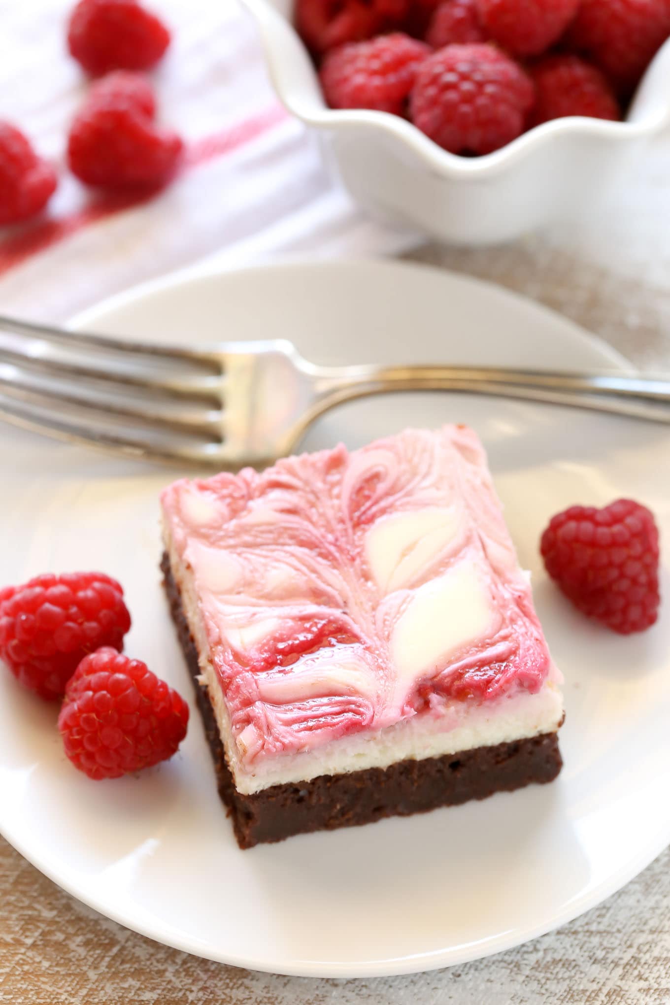 A fudgy brownie base topped with a smooth and creamy cheesecake layer and a raspberry swirl. These Raspberry Cheesecake Brownies make a beautiful dessert for any occasion!