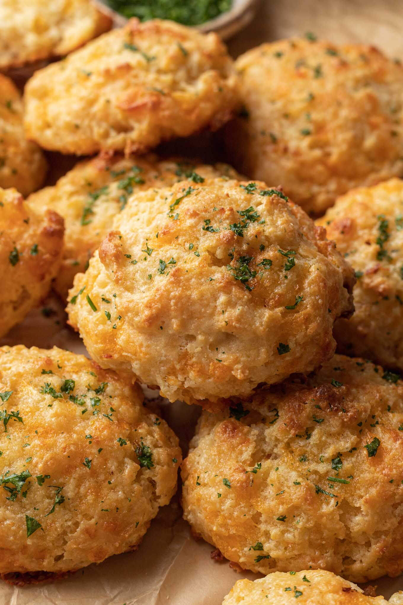 A close-up view of a pile of homemade Red Lobster cheese biscuits. 