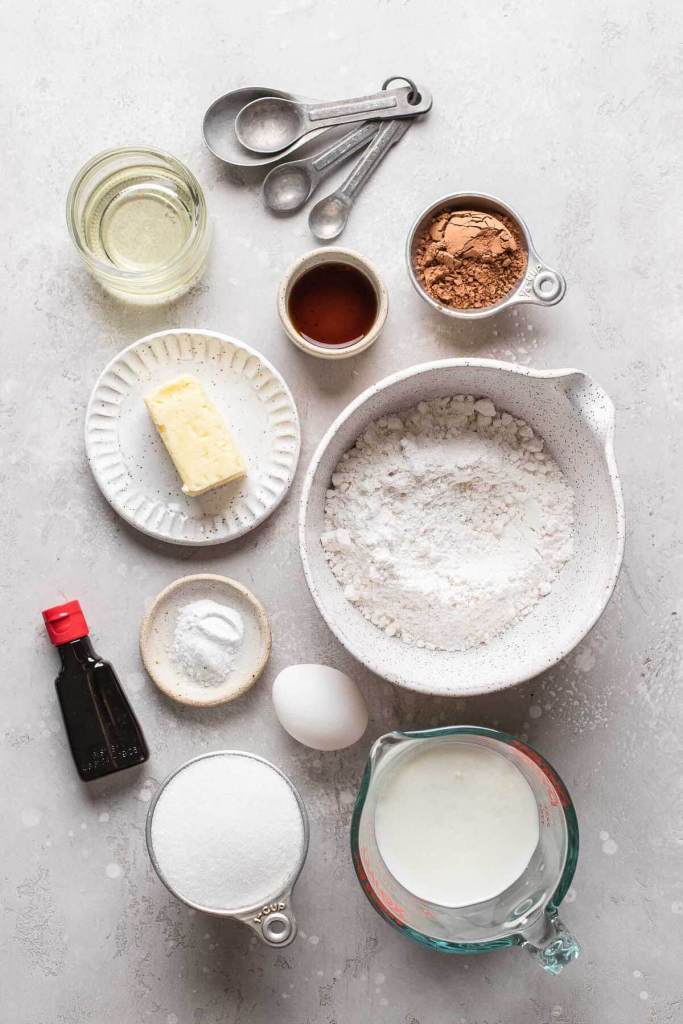 An overhead view of the ingredients needed to make red velvet cupcakes with cream cheese frosting. 