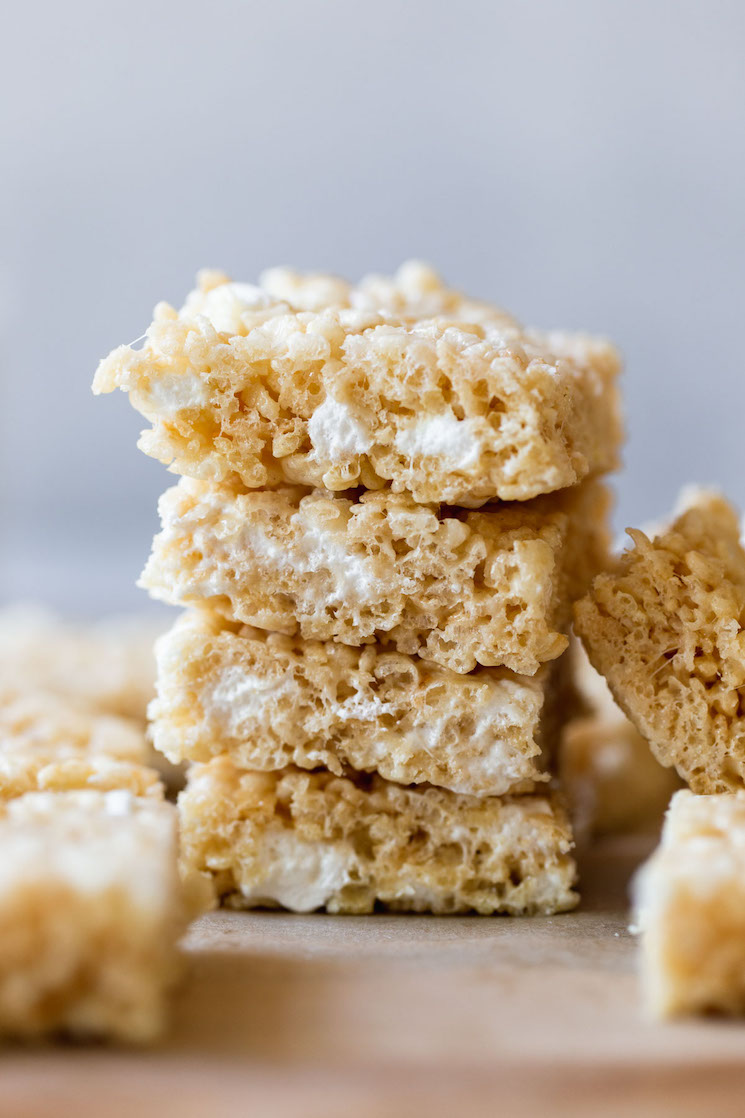 A stack of Rice Krispie treats on a wooden tray.