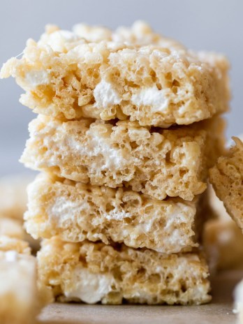 A stack of Rice Krispie treats on top of a wooden tray.