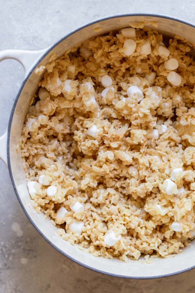 A dutch oven with the cereal mixed into the melted butter and marshmallows.