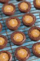 Salted caramel brownie bites sitting on top of a wire cooling rack.