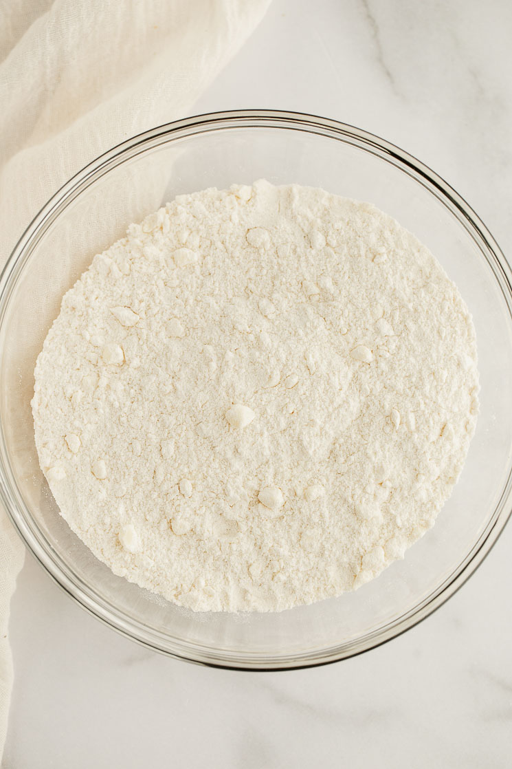 The dry ingredients needed to make this scone recipe in a glass bowl.