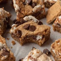 Several s'mores bars on a piece of white parchment paper.