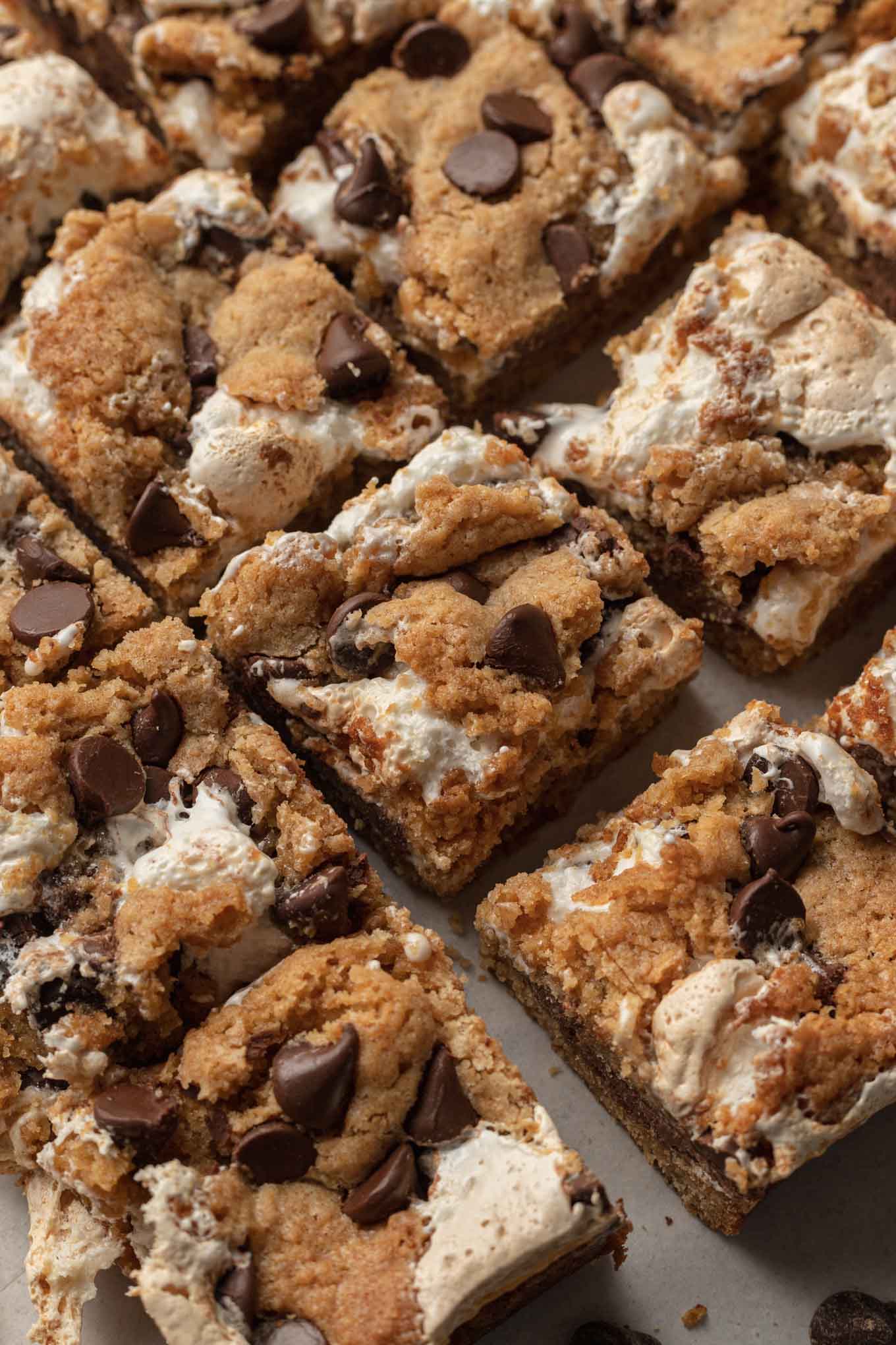 Sliced s'mores bars lined up on parchment paper. 