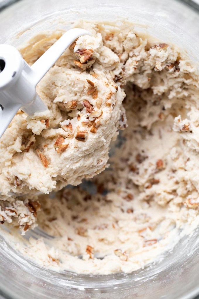 A glass mixing bowl filled with cookie dough.