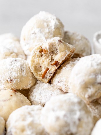 A batch of snowball cookies on a cooling rack.