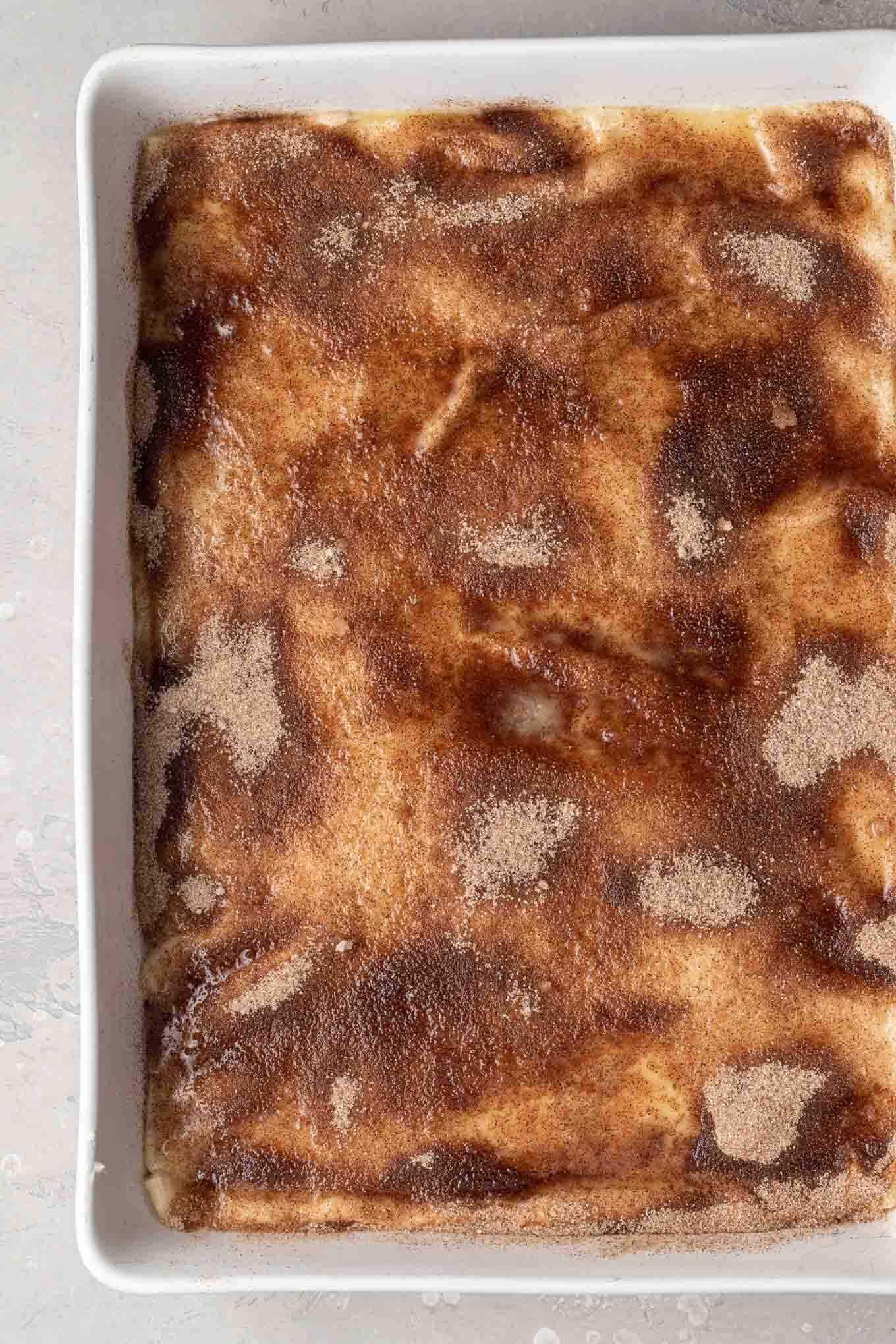 An overhead view of a cinnamon-sugar topped sopapilla cheesecake, ready to be baked. 
