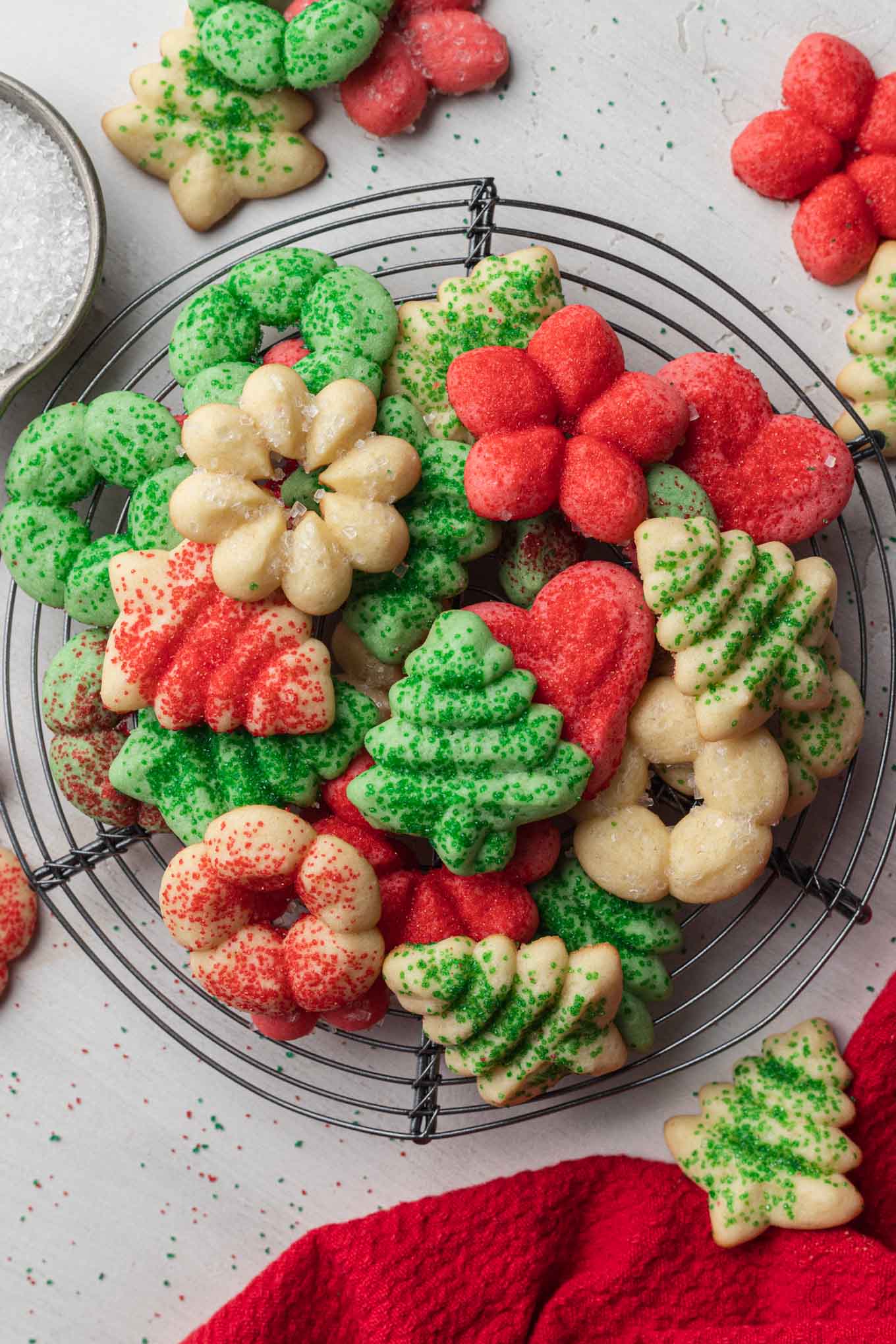 An overhead view of red, white, and green butter spritz cookies on a wire cooling rack. 