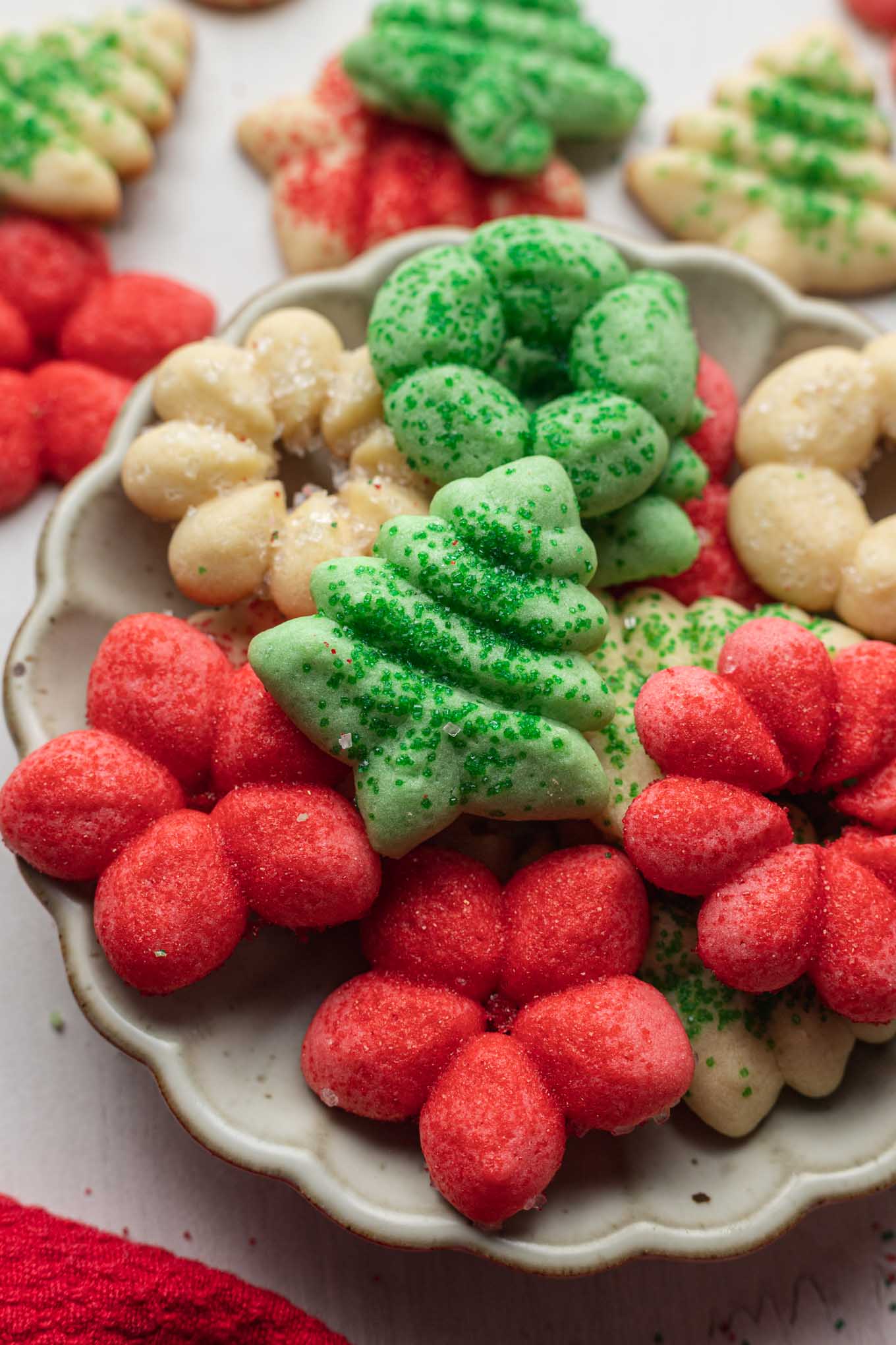 A serving dish of butter spritz cookies, with more cookies in the background. 