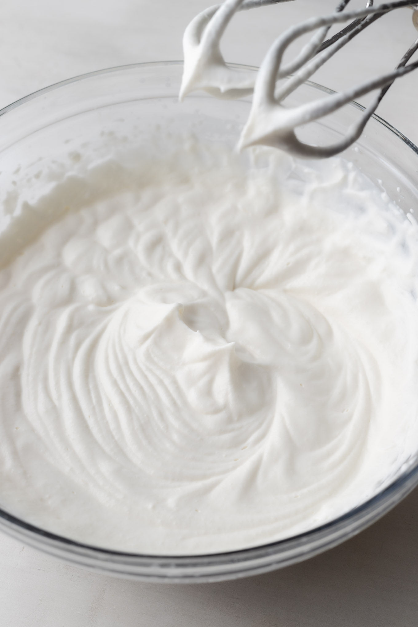 An overhead view of whipped cream beaten to stiff peaks.