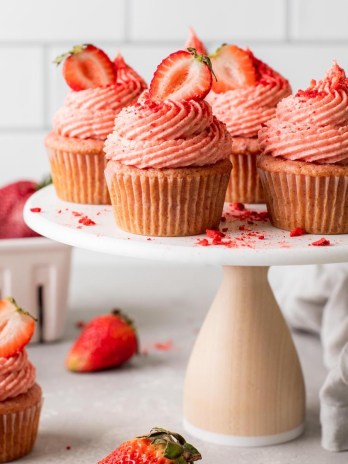 A side view of fresh strawberry cupcakes on a cake stand.