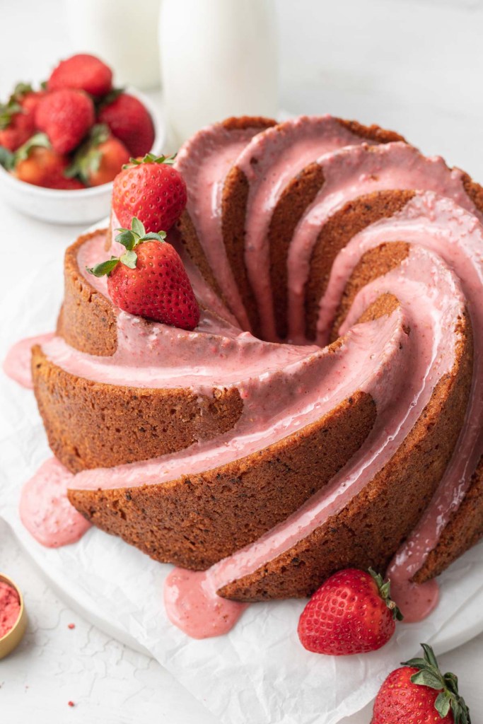 A glazed strawberry pound cake, garnished with fresh berries. 