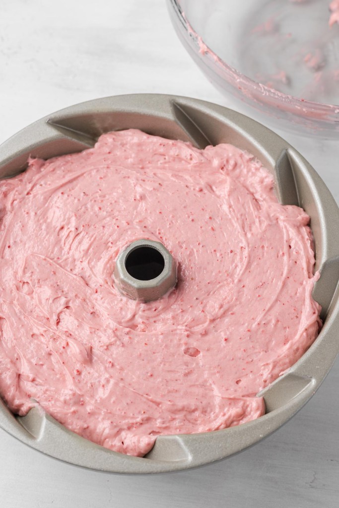 Strawberry pound cake batter in a metal bundt pan. 