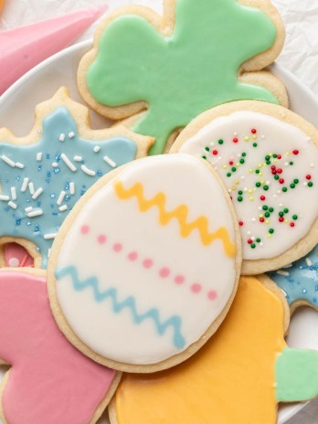 Several iced sugar cookies on a white plate.