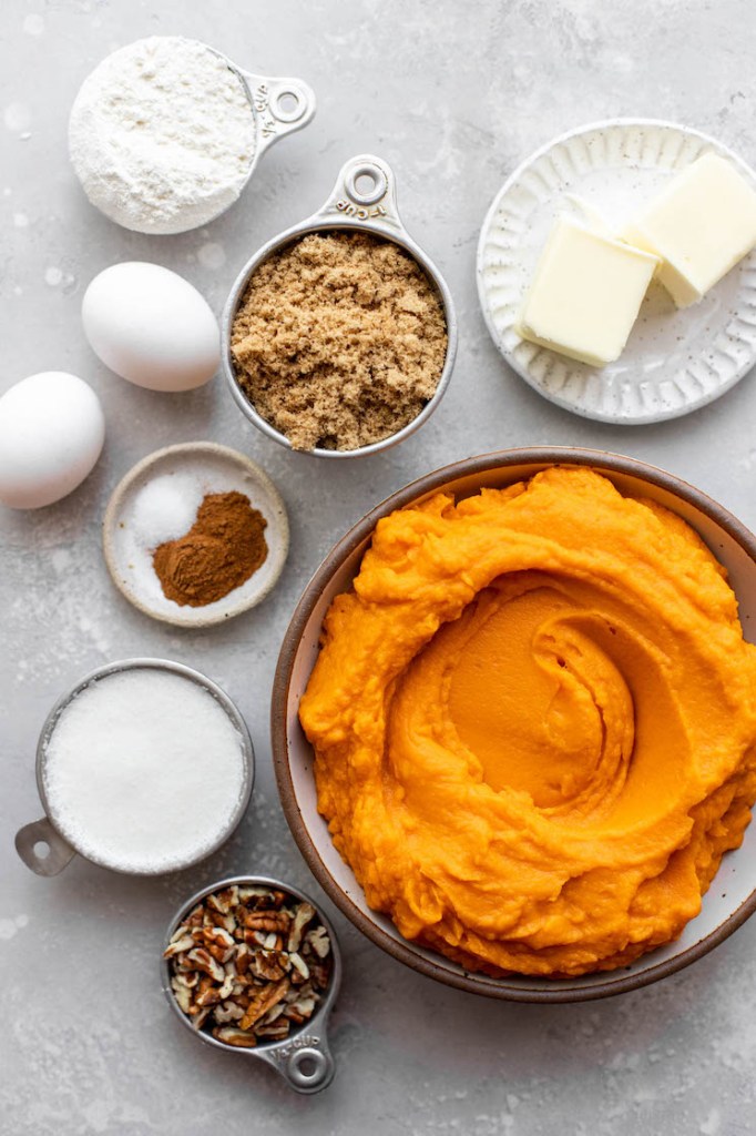 The ingredients needed to make a sweet potato casserole on top of a gray surface.