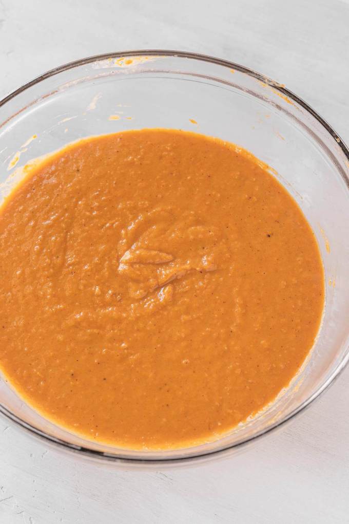 An overhead view of sweet potato pie filling in a glass mixing bowl.