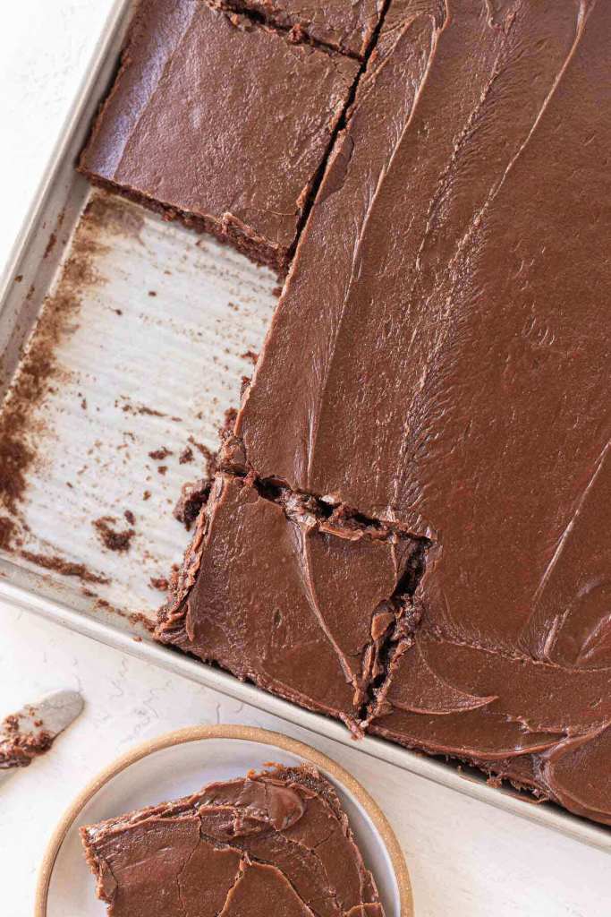 An overhead view of a Texas sheet cake. The cake has been sliced and a slice has been removed.