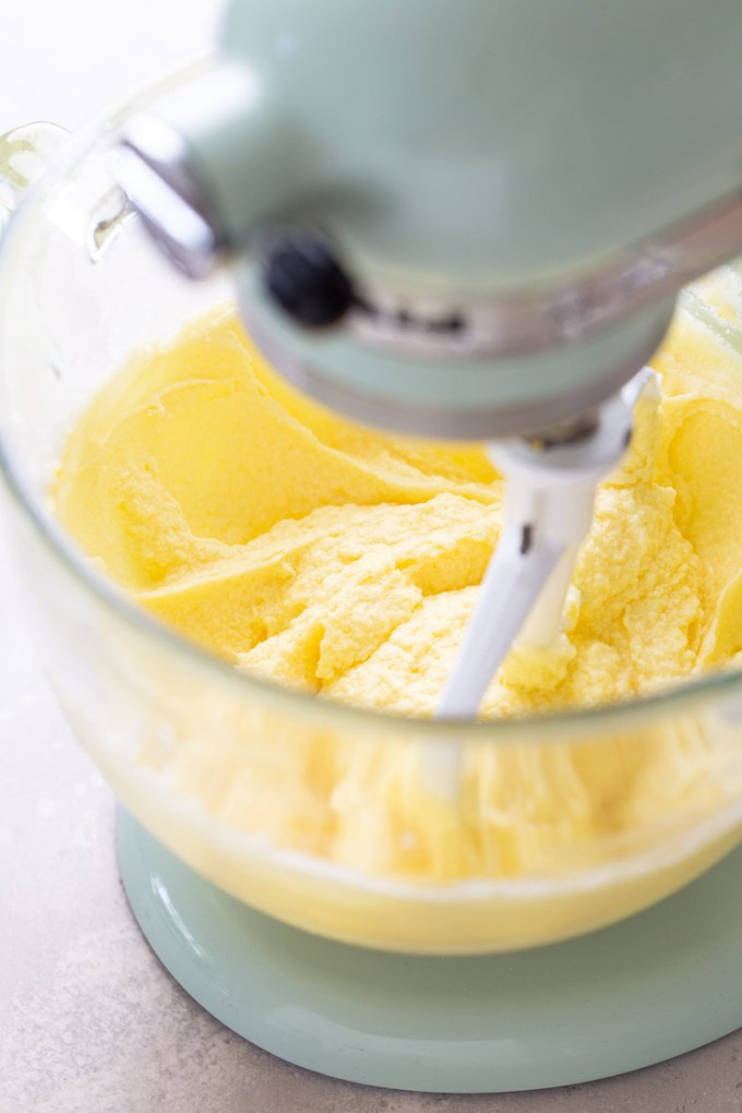 Process shot showing butter, sugar, and eggs being mixed together in a stand mixer.