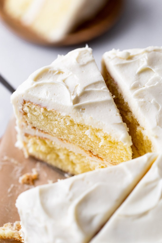 Overhead view of a sliced vanilla cake. Once slice has already been removed. 