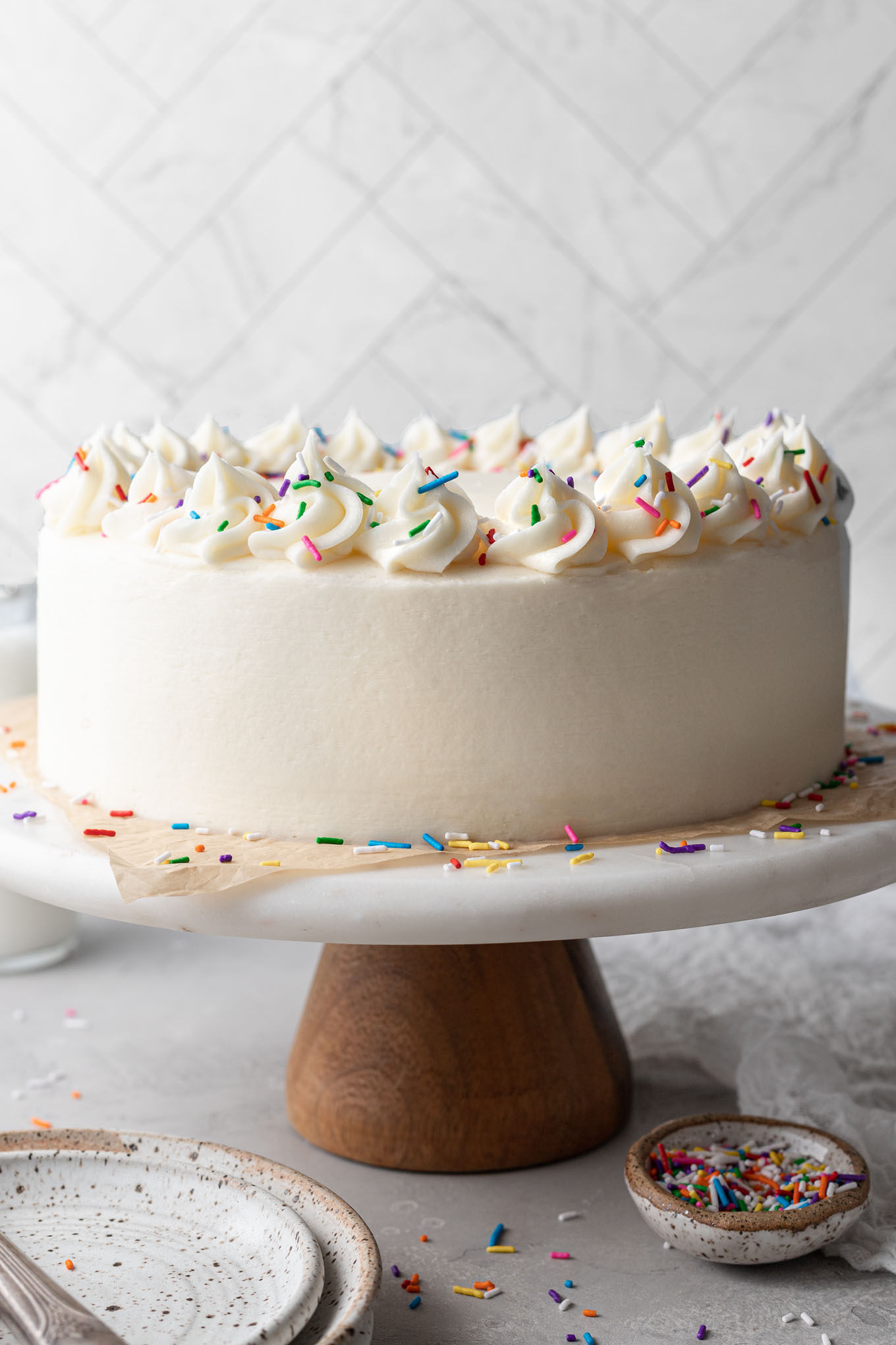 A frosted white cake on a cake stand. 